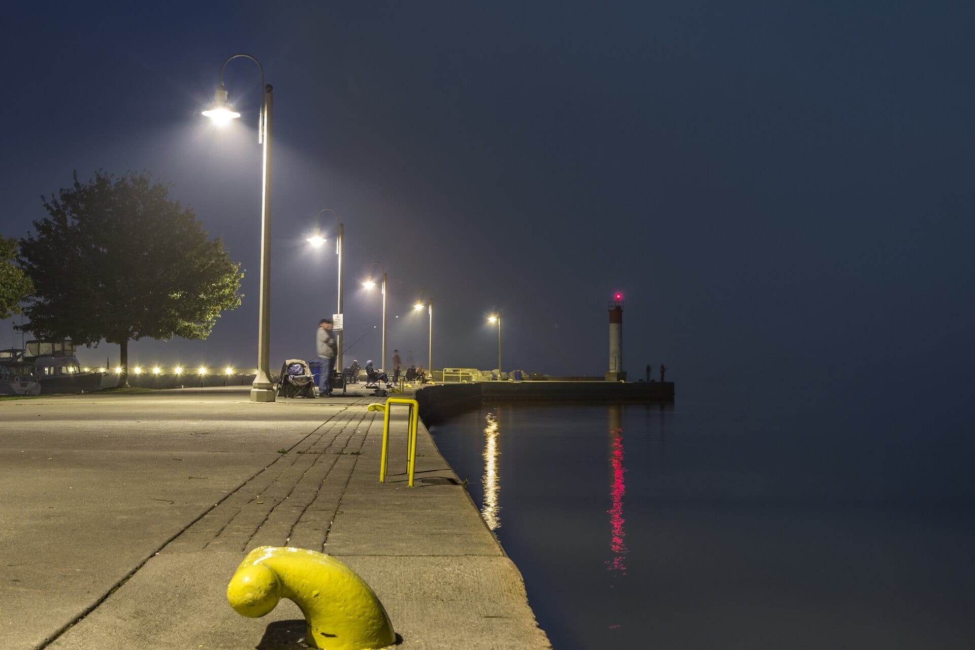 Bronte Harbour pier in Oakville at night, lamps reflecting on the calm lake.