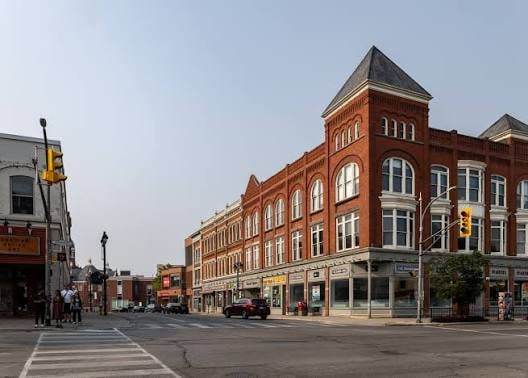A red-brick corner building with turrets at a downtown Stratford intersection.